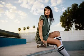 Beautiful skateboarder sitting at skate park